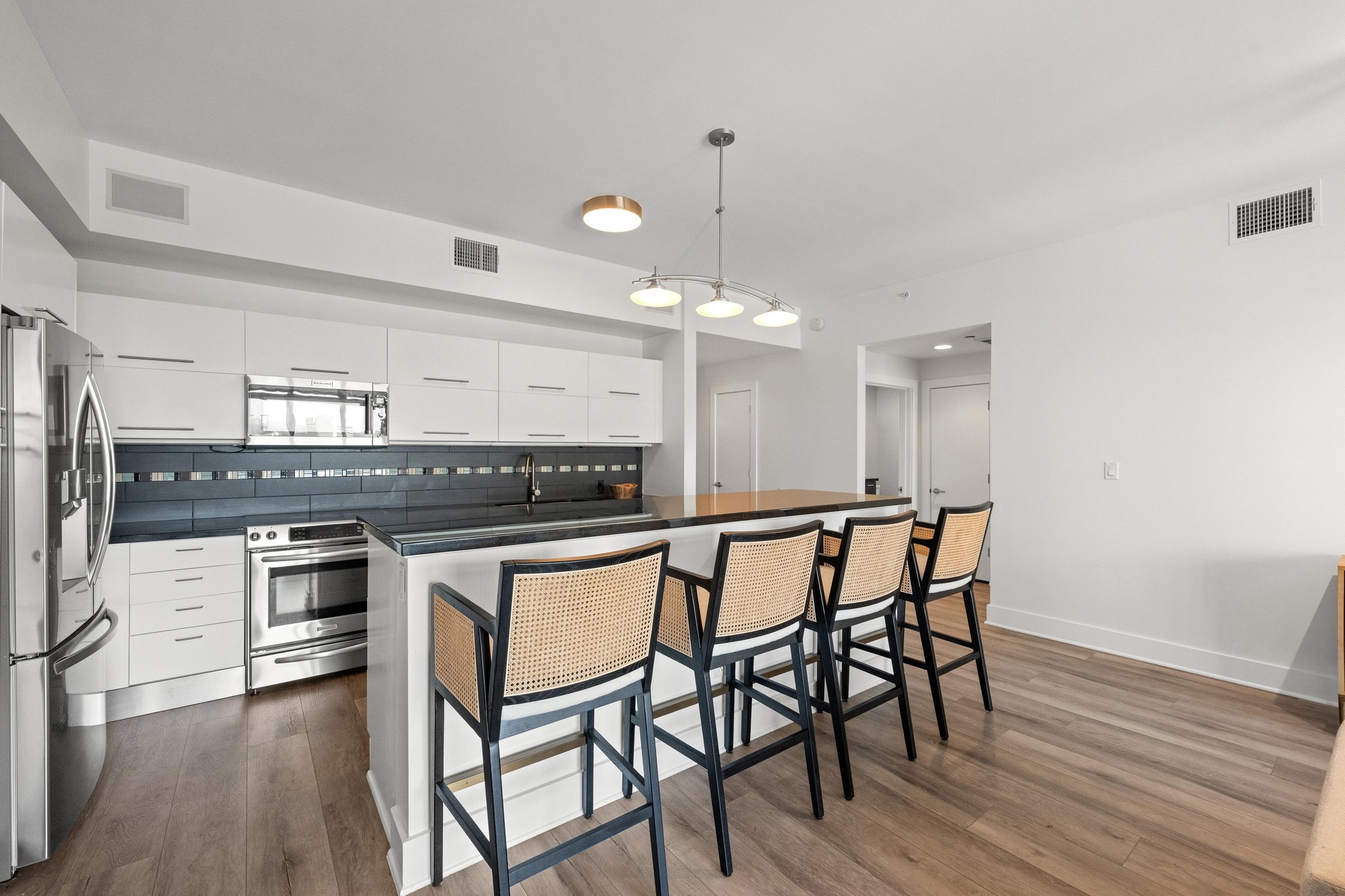 603 Davis Street, Unit 1002 Austin, TX 78701 - Photo 6 of 40 a kitchen with stainless steel appliances a dining table chairs and wooden floor