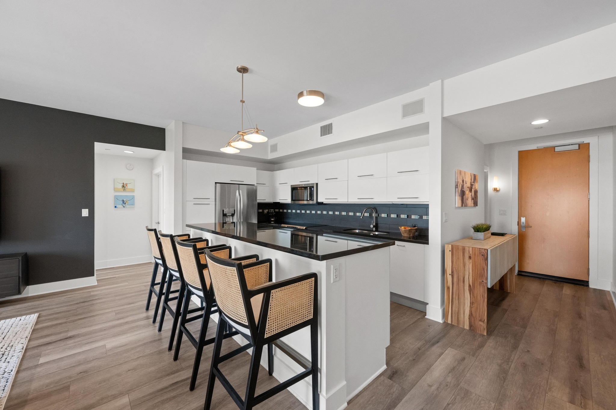 603 Davis Street, Unit 1002 Austin, TX 78701 - Photo 7 of 40 a kitchen with stainless steel appliances kitchen island granite countertop a table chairs and a refrigerator