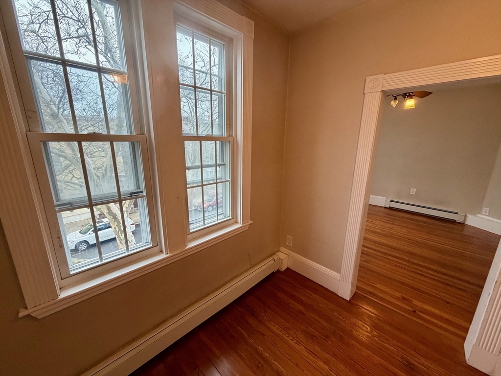 324 Chelsea Street, Unit 3 Boston, MA 02128 - Photo 17 of 20 a view of an empty room with wooden floor and a window