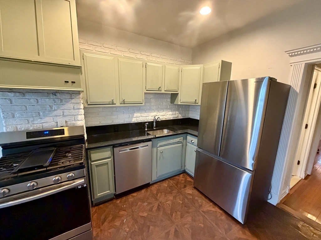324 Chelsea Street, Unit 3 Boston, MA 02128 - Photo 3 of 20 a kitchen with granite countertop a refrigerator and a stove top oven