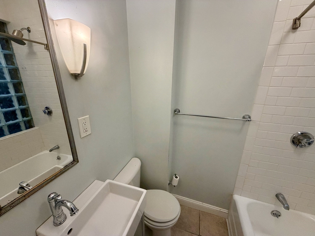324 Chelsea Street, Unit 3 Boston, MA 02128 - Photo 7 of 20 a white toilet sitting next to a bathroom sink and tub