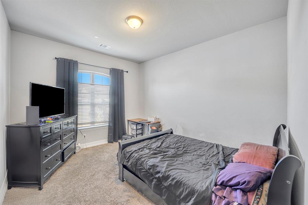 1340 Driftwood Lane Lucas, TX 75002 - Photo 21 of 23 a bedroom with a bed and a flat screen tv