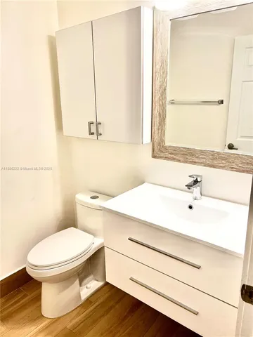 a bathroom with a sink a toilet and mirror