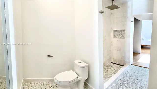 a bathroom with a toilet and a shower