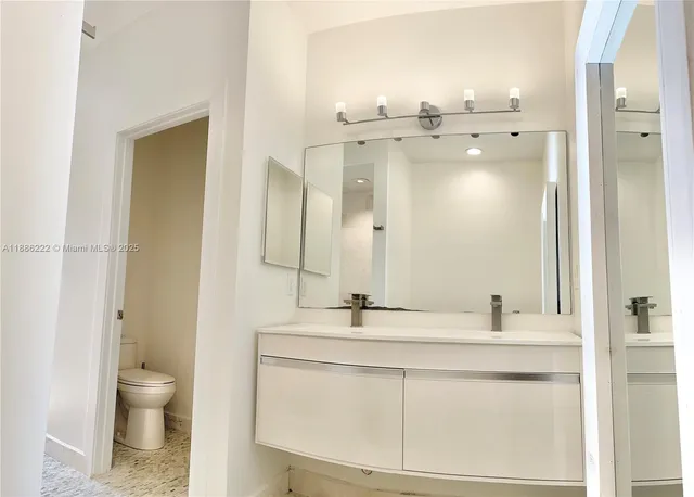 a bathroom with a sink toilet a mirror and shower