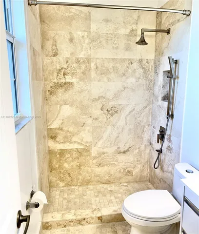 a white toilet sitting next to a shower curtain