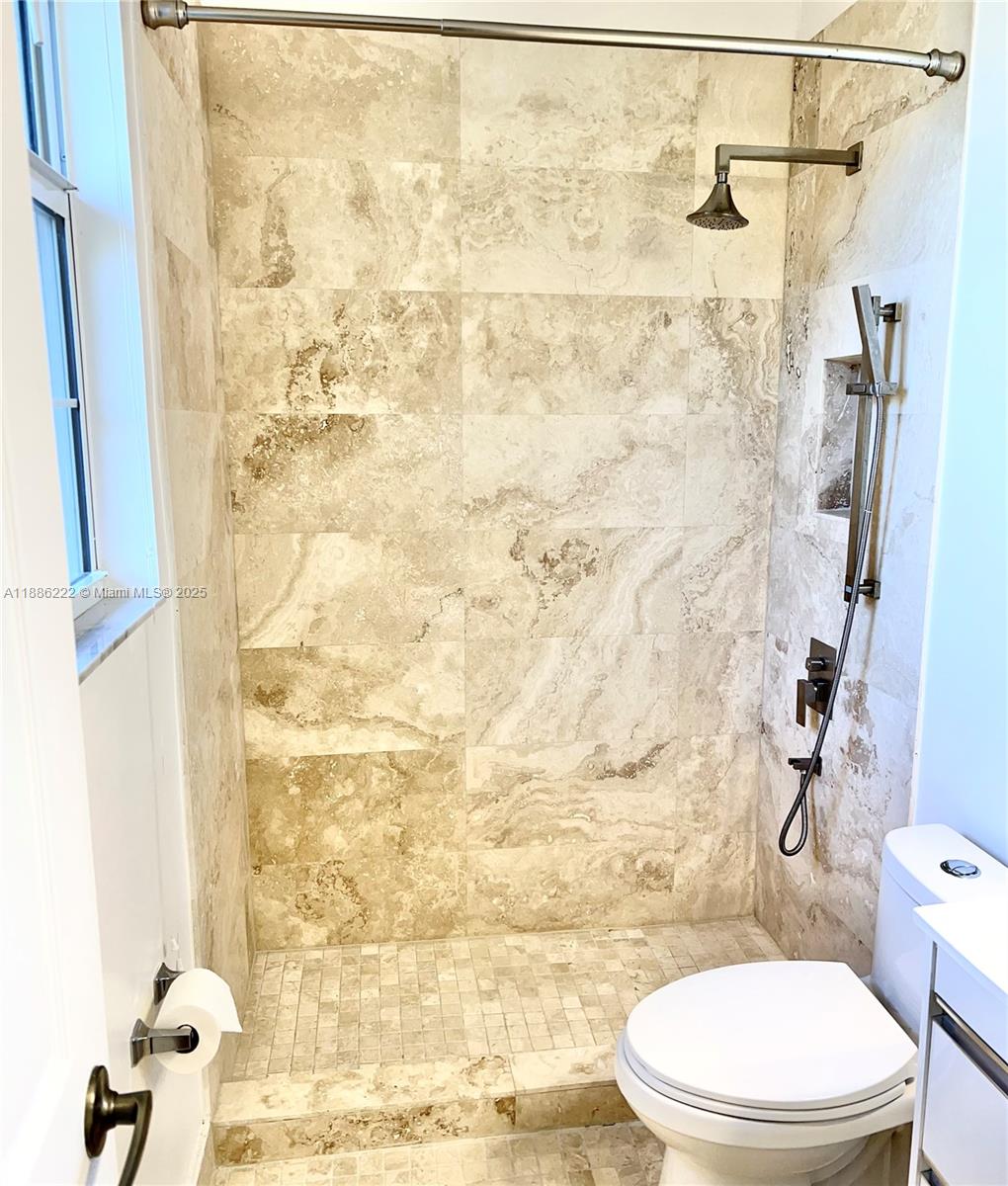 2549 Southwest 118th Way, Unit 302 Miramar, FL 33025 - Photo 27 of 43 a white toilet sitting next to a shower curtain