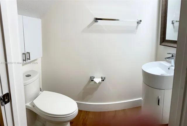 a white toilet sitting next to a bathroom sink