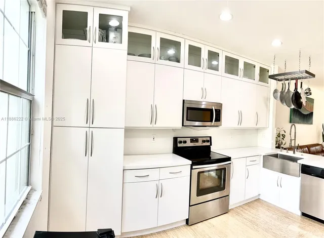 a kitchen with stainless steel appliances a refrigerator stove and microwave