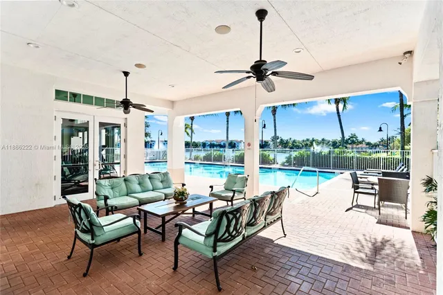 a living room with furniture ceiling fan and a floor to ceiling window