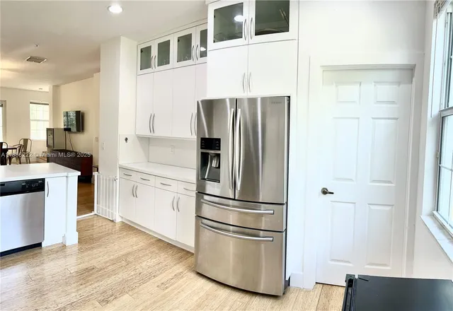 a kitchen with stainless steel appliances granite countertop a refrigerator and a sink
