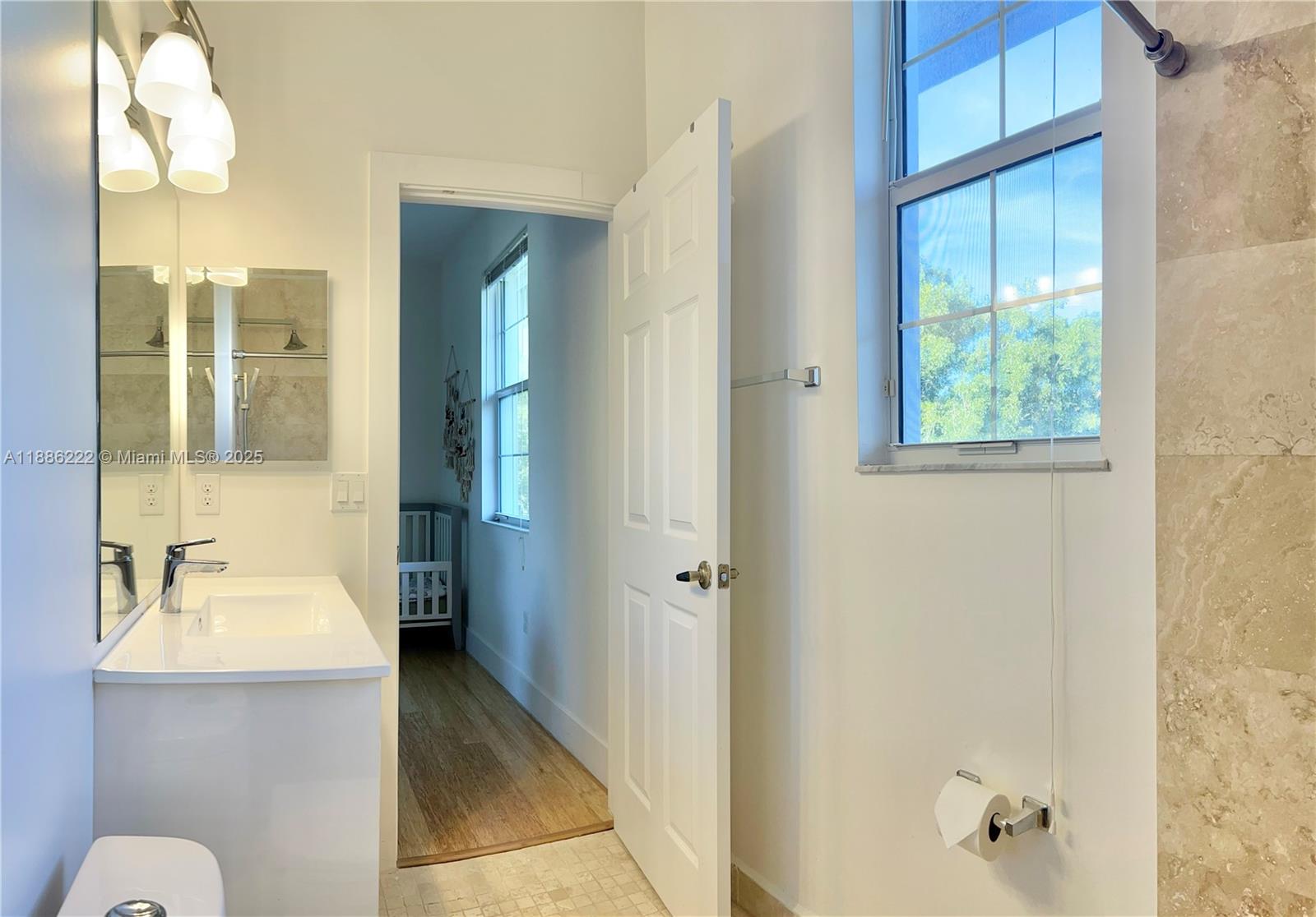 2549 Southwest 118th Way, Unit 302 Miramar, FL 33025 - Photo 10 of 43 a bathroom with a sink a mirror and a shower