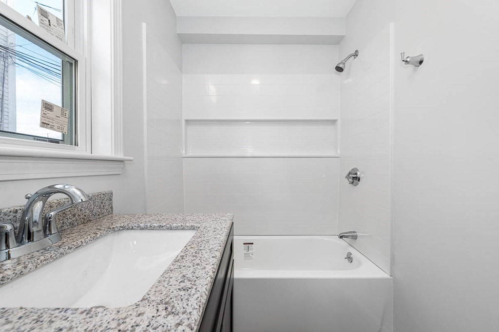 40 Everett Avenue Somerville, MA 02145 - Photo 13 of 21 a bathroom with a tub sink and mirror