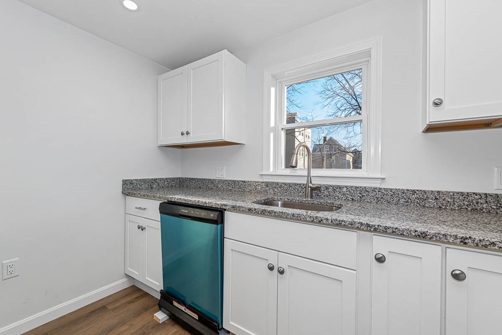 40 Everett Avenue Somerville, MA 02145 - Photo 16 of 21 a kitchen with granite countertop white cabinets and a window