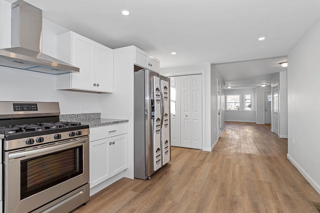 40 Everett Avenue Somerville, MA 02145 - Photo 17 of 21 a kitchen with granite countertop wooden floors and stainless steel appliances