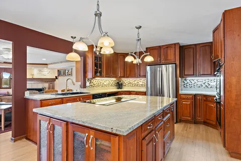 a kitchen with stainless steel appliances granite countertop a sink a stove and a wooden floors