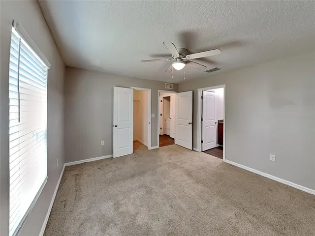 an empty room with fan and windows
