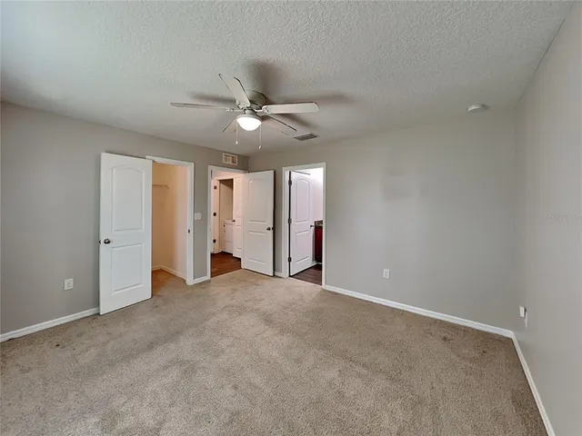 an empty room with fan and a ceiling fan