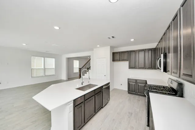 a kitchen with stainless steel appliances a sink stove and cabinets