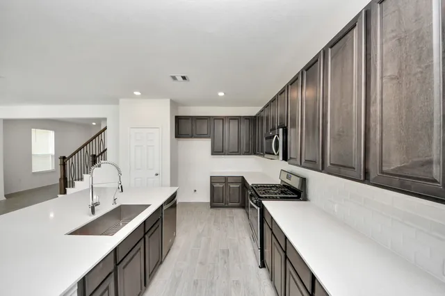 a kitchen with a sink stove and cabinets