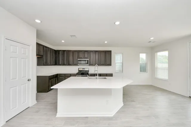 a large white kitchen with a large window