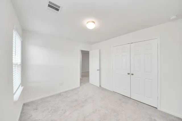 an empty room with windows and closet