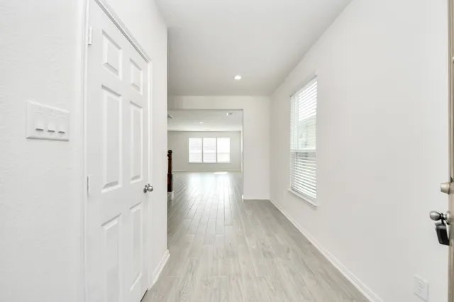 a view of a hallway with wooden floor and closet