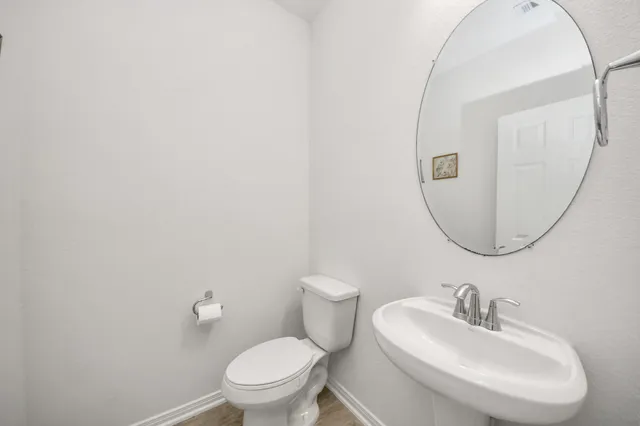 a bathroom with a toilet a sink and mirror