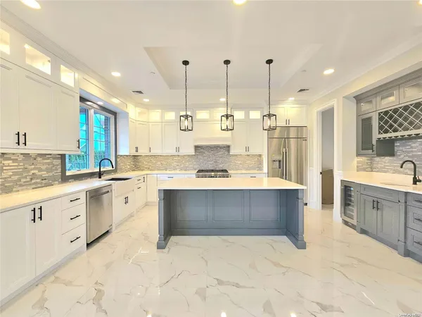 a large kitchen with kitchen island a sink stainless steel appliances and cabinets