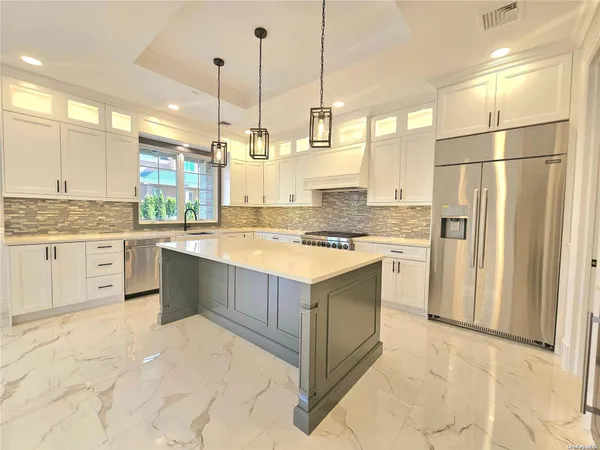 a kitchen with a sink a counter top space cabinets and stainless steel appliances