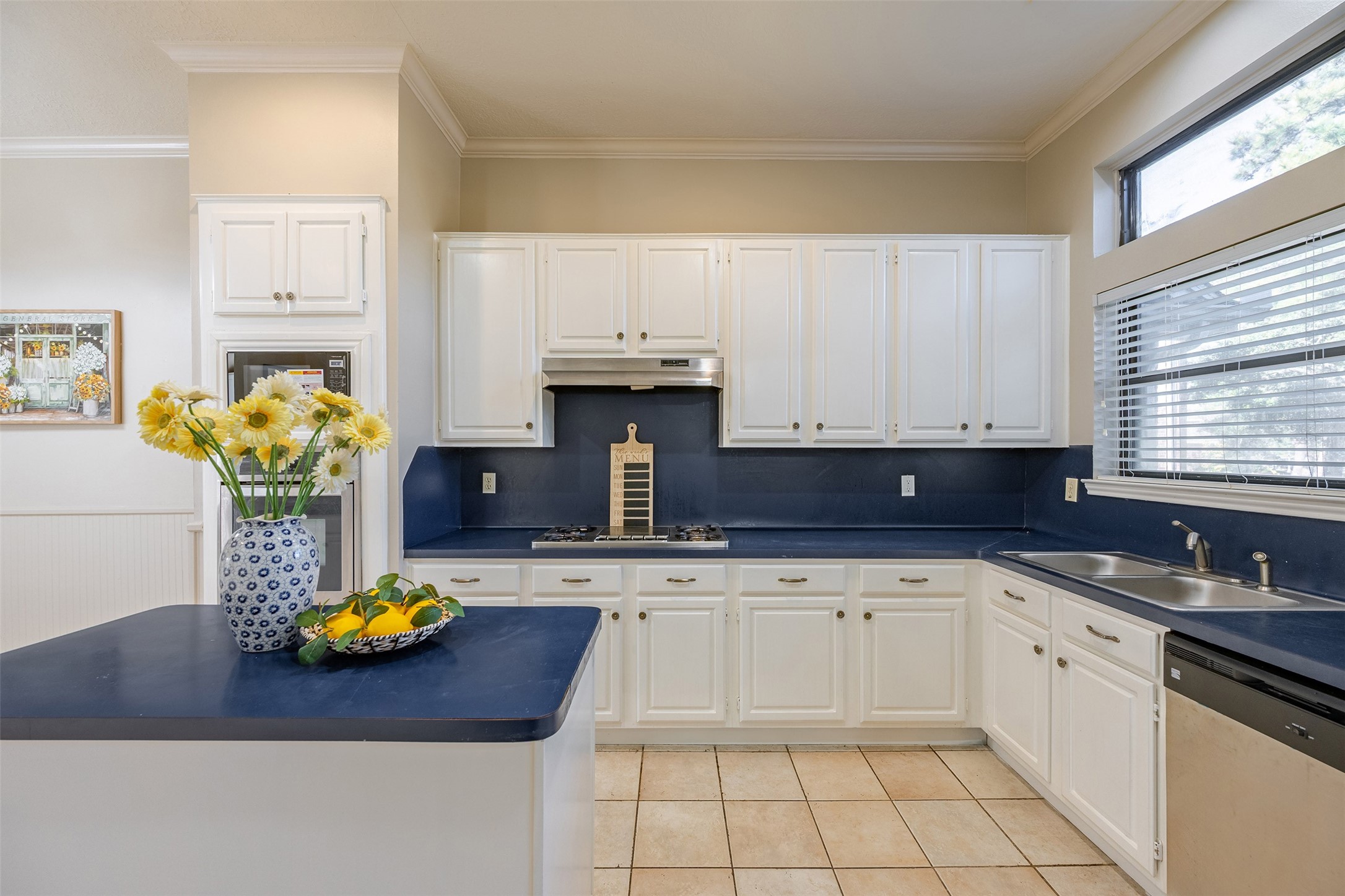 a kitchen with a sink a stove cabinets and a window