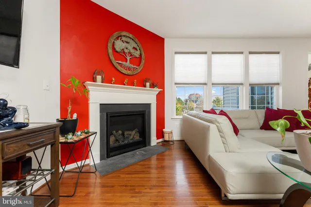 a living room with furniture a fireplace and a floor to ceiling window
