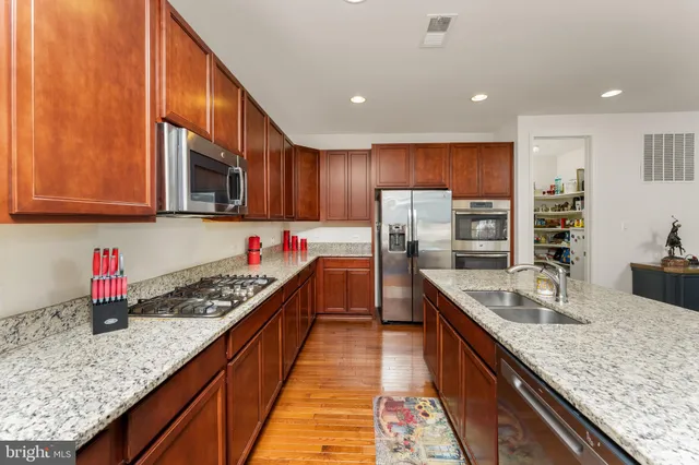 a kitchen with stainless steel appliances granite countertop a stove a sink and a refrigerator