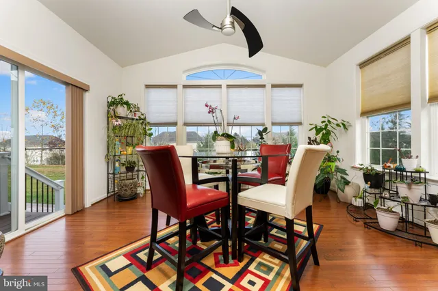 a dining room with furniture window and wooden floor