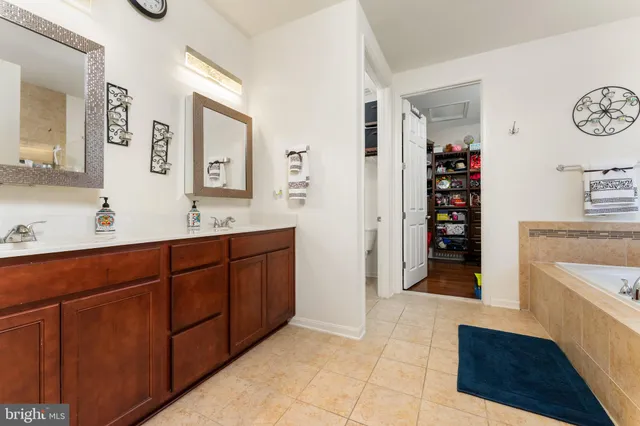 a spacious bathroom with double vanity and a mirror