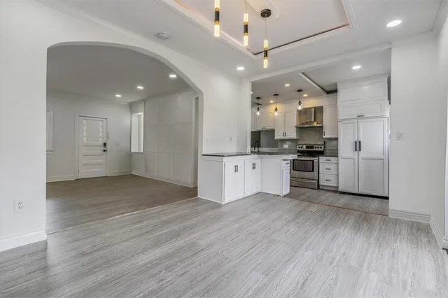 a large kitchen with stainless steel appliances kitchen island a large counter top and a stove top oven