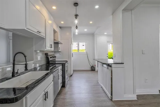 a kitchen with kitchen island granite countertop a sink stainless steel appliances and cabinets