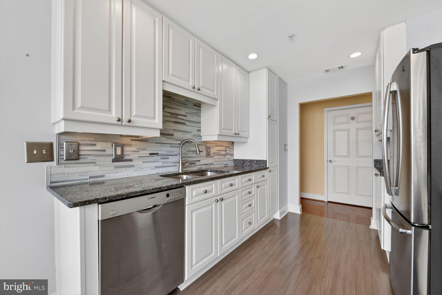 11776 Stratford House Place, Unit 502 Reston, VA 20190 - Photo 12 of 35 a kitchen with stainless steel appliances granite countertop a stove sink and cabinets