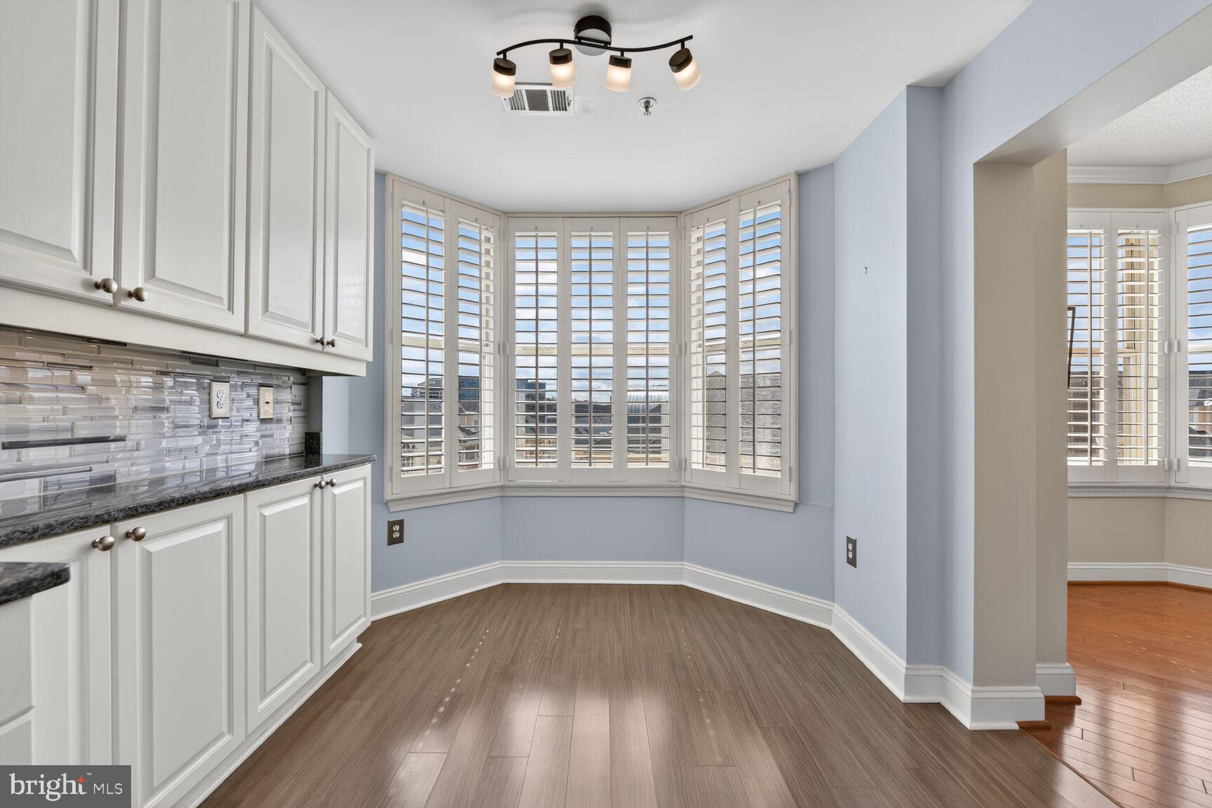 11776 Stratford House Place, Unit 502 Reston, VA 20190 - Photo 12 of 34 a kitchen with granite countertop white cabinets and wooden floor