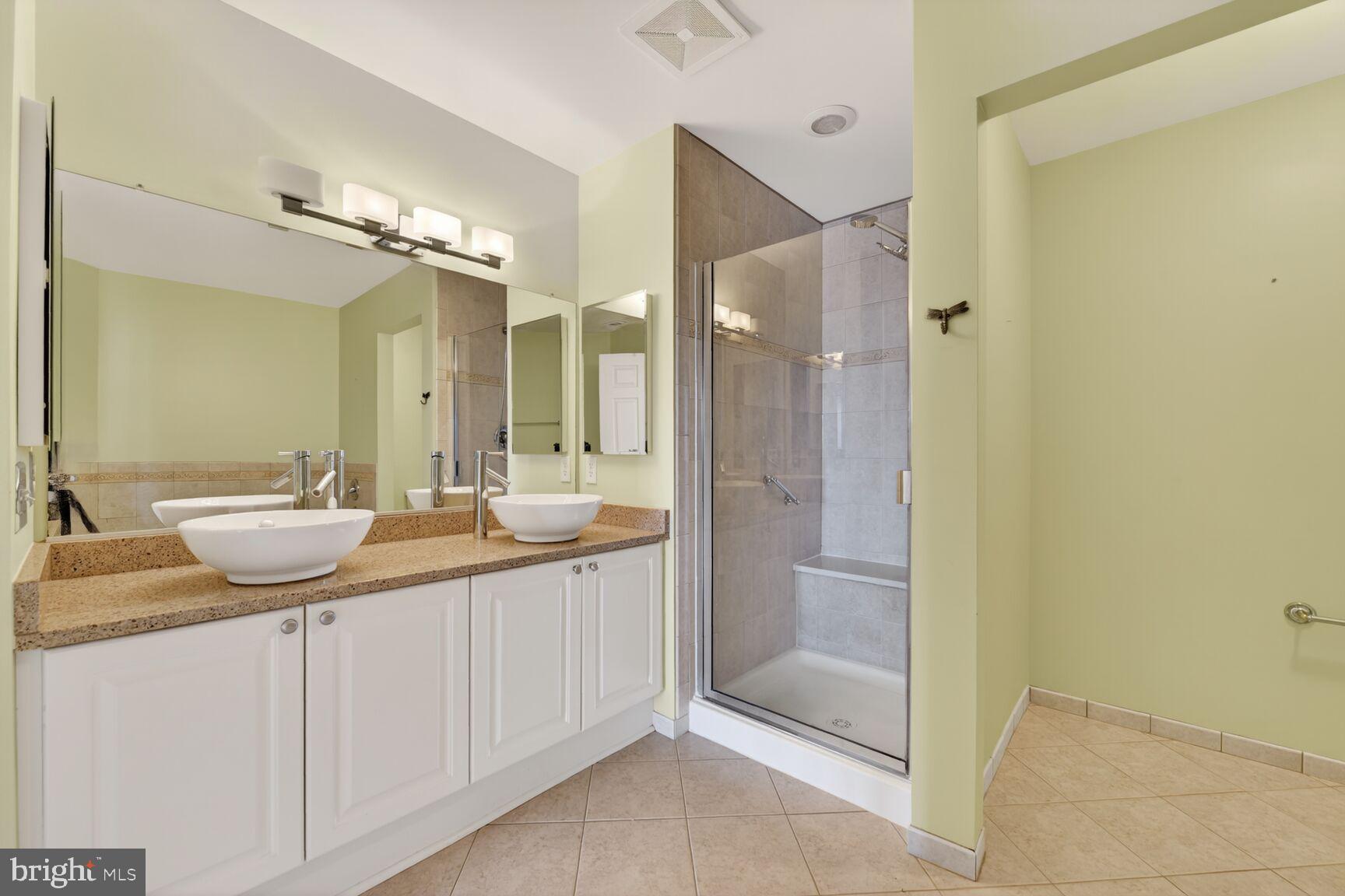11776 Stratford House Place, Unit 502 Reston, VA 20190 - Photo 17 of 35 a bathroom with a granite countertop sink and a mirror