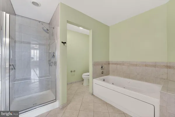 a bathroom with a granite countertop sink a toilet and shower