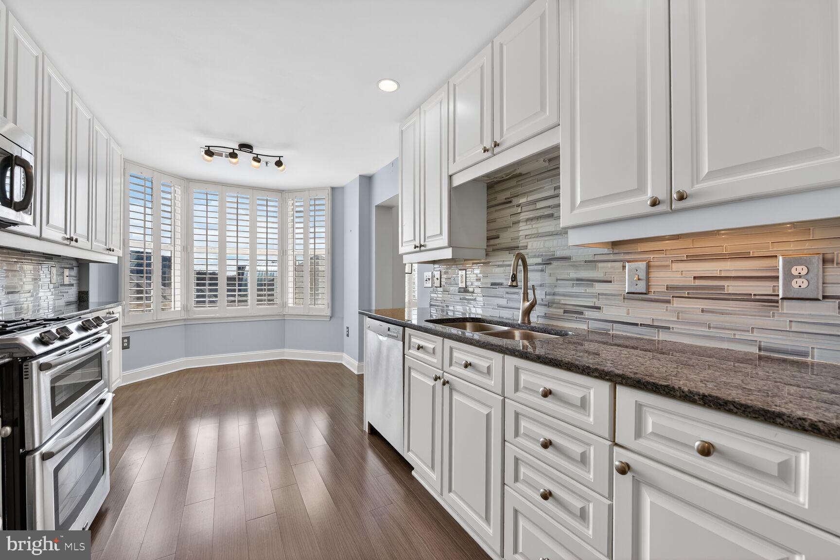 11776 Stratford House Place, Unit 502 Reston, VA 20190 - Photo 2 of 35 a kitchen with granite countertop a stove sink and cabinets