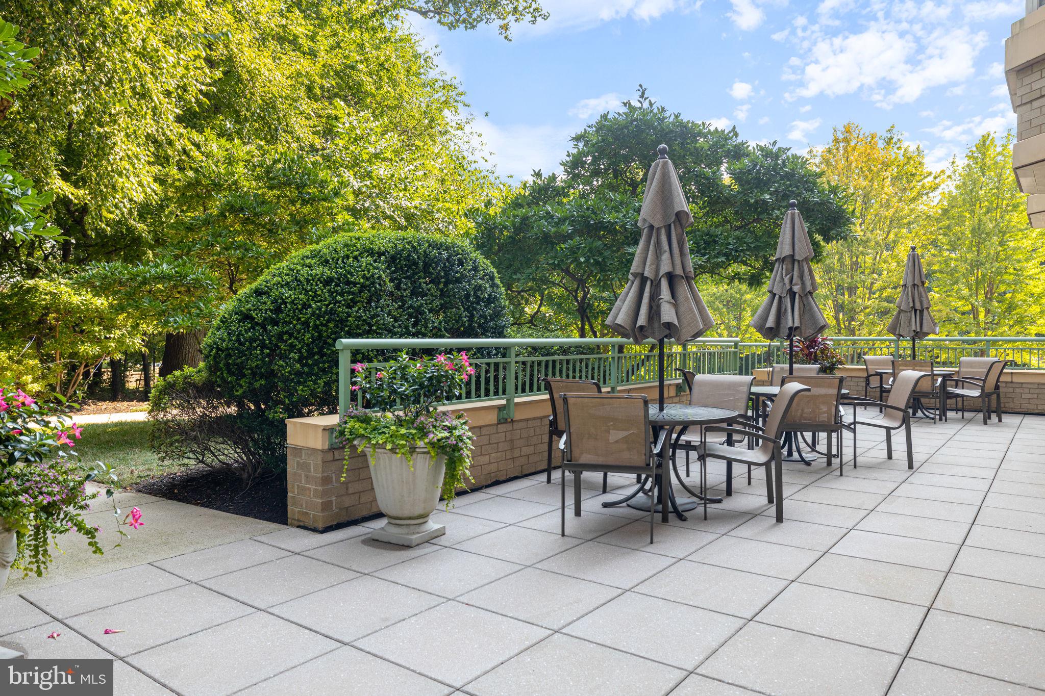 11776 Stratford House Place, Unit 502 Reston, VA 20190 - Photo 30 of 35 a view of a patio with a dining table and chairs with wooden fence
