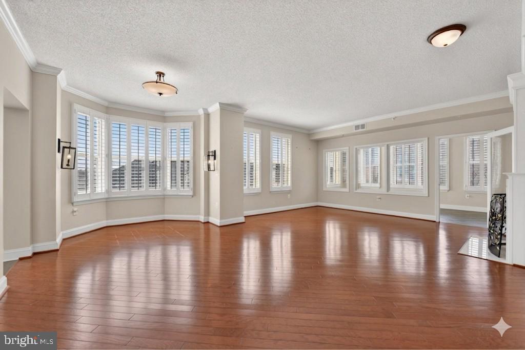 11776 Stratford House Place, Unit 502 Reston, VA 20190 - Photo 7 of 34 a view of an empty room with window and wooden floor
