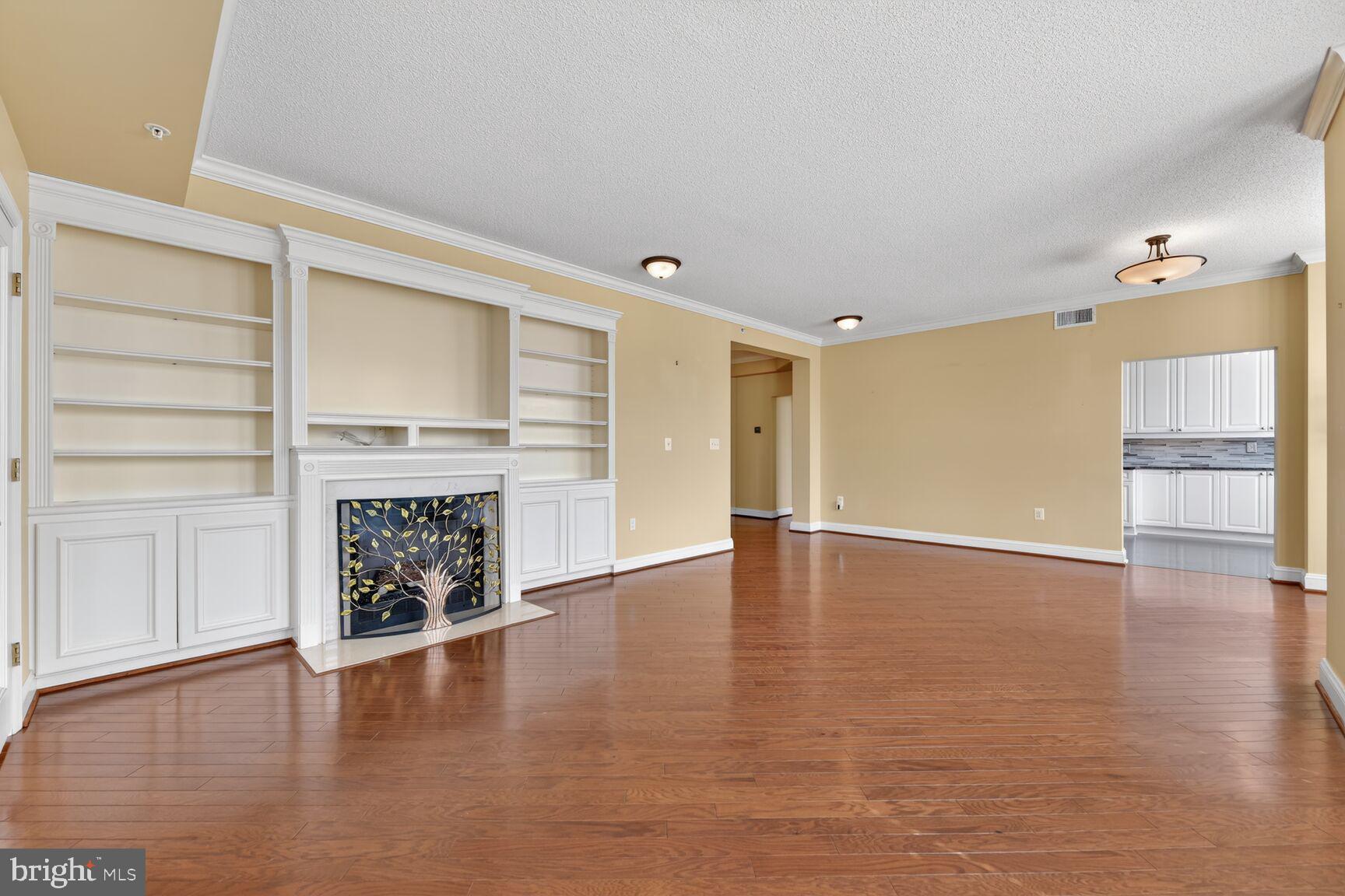 11776 Stratford House Place, Unit 502 Reston, VA 20190 - Photo 8 of 35 an empty room with wooden floor fireplace and windows