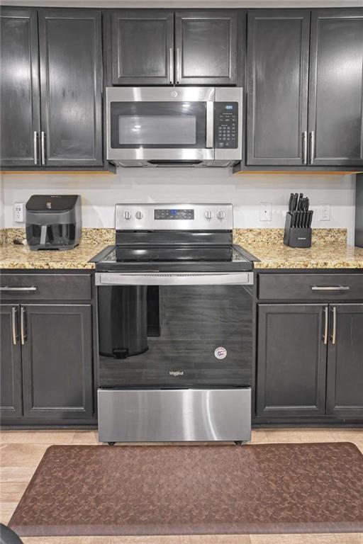 12001 Guelph Circle Hampton, GA 30228 - Photo 14 of 31 a kitchen with granite countertop stainless steel appliances and wooden cabinets