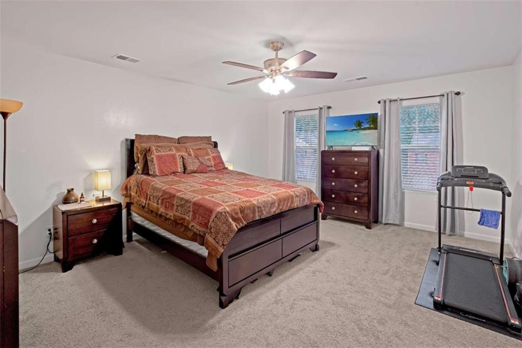 12001 Guelph Circle Hampton, GA 30228 - Photo 16 of 31 a bedroom with a bed and cabinets