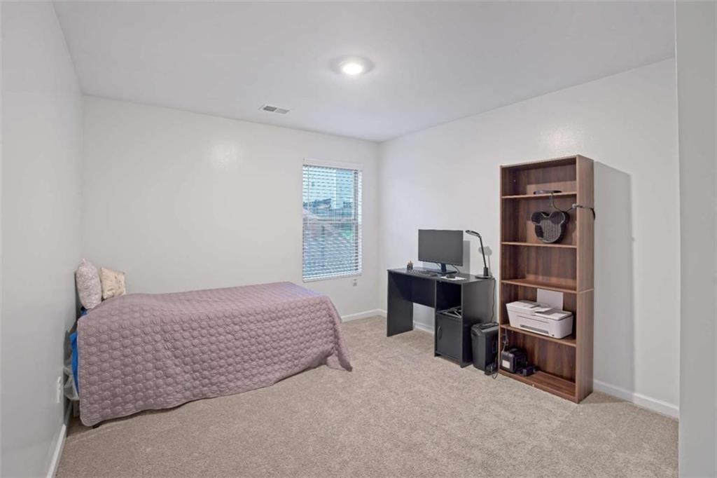 12001 Guelph Circle Hampton, GA 30228 - Photo 22 of 31 a bedroom with a bed and a couch