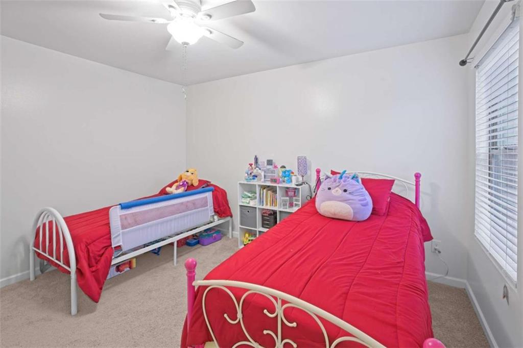 12001 Guelph Circle Hampton, GA 30228 - Photo 26 of 31 a bedroom with two beds and a chandelier