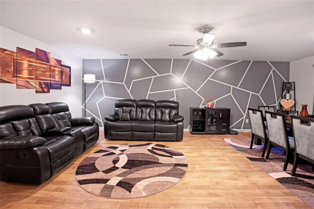 12001 Guelph Circle Hampton, GA 30228 - Photo 7 of 31 a living room with furniture a rug and a chandelier